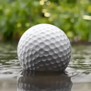 A close up image of a golf ball in the lake
