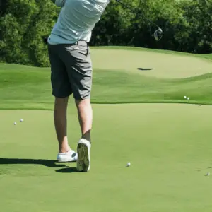 A golfer swings a club with hips turned