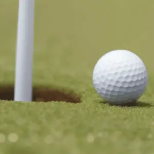 A white golf ball near the hole