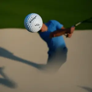 An up-close view of a golf ball that has been struck by a golfer
