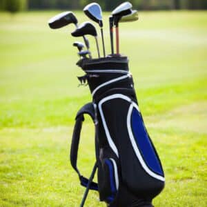A golf bag with various golf clubs standing upright in a lush green grass field