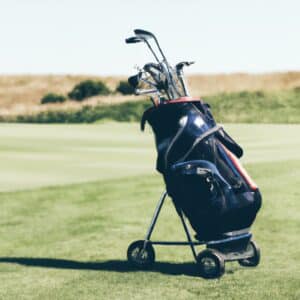 A golf trolley with a black frame and three wheels