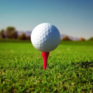 A red golf tee with a white golf ball resting on top