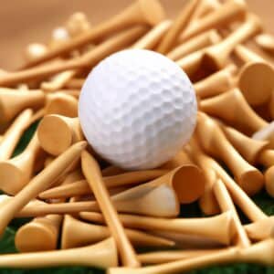 A white golf ball surrounded by several wooden tees on a flat surface