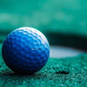 a blue golf ball on  a mini golf mat