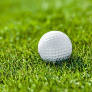 A golf ball resting on a manicured grass field