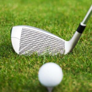 an iron golf clubhead and a golf ball on the course