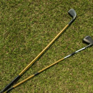 two golf clubs with gold shafts on the course