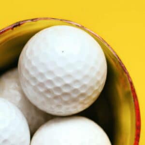 used golf balls in a small bucket