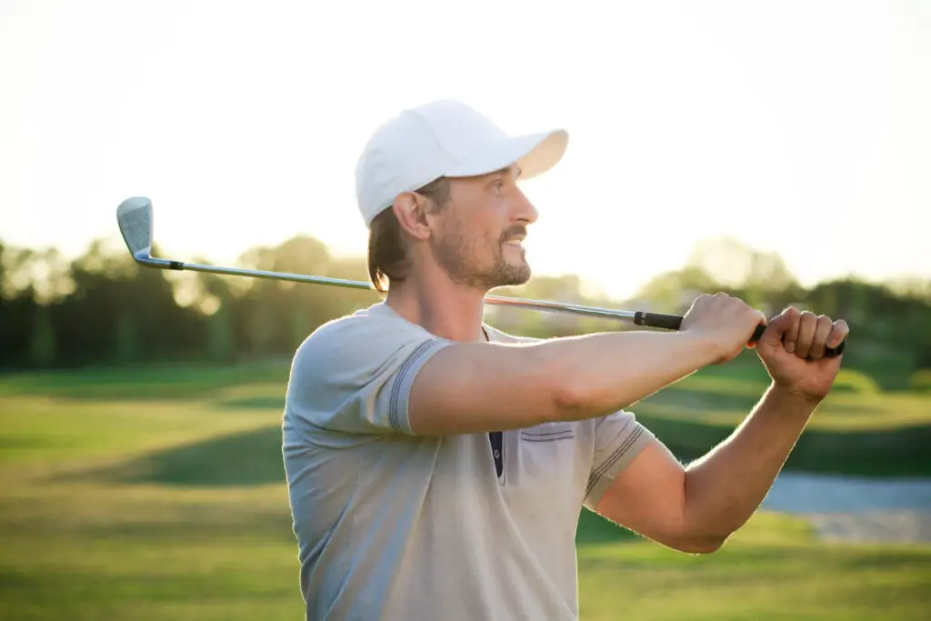 a man holding golf club on shoulder
