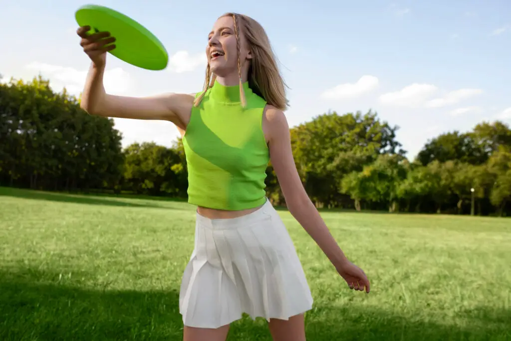 a woman holding frisbee disc in a field