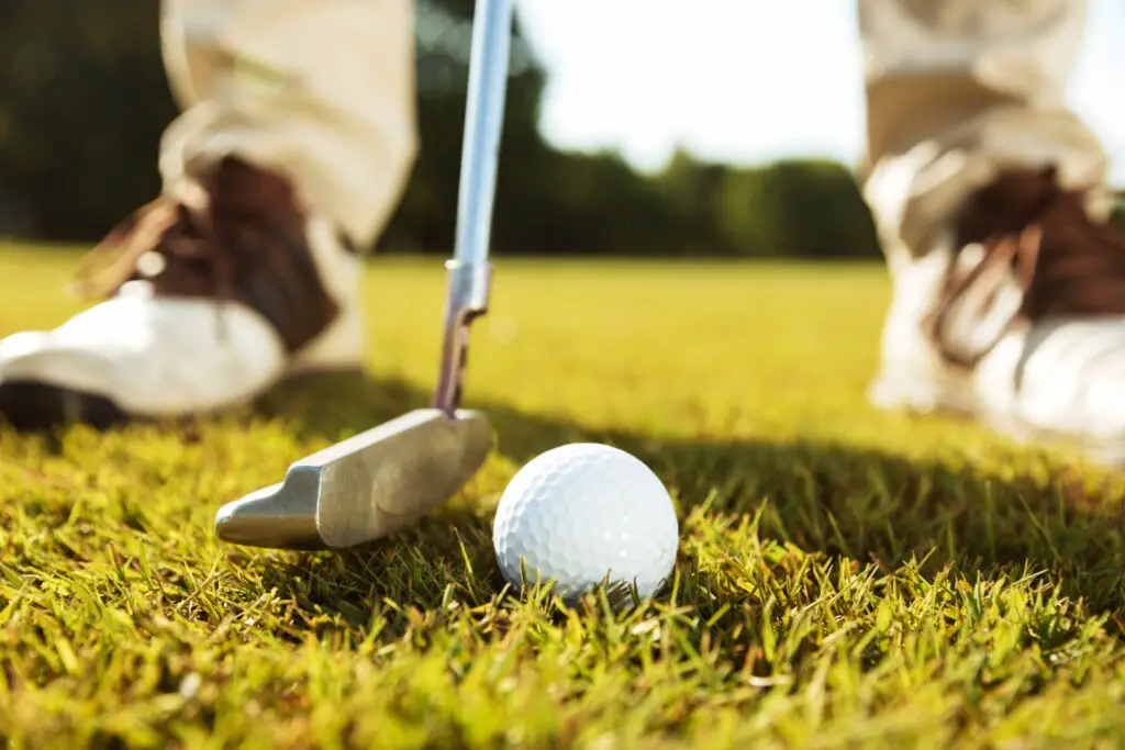 close up male golfer teeing off