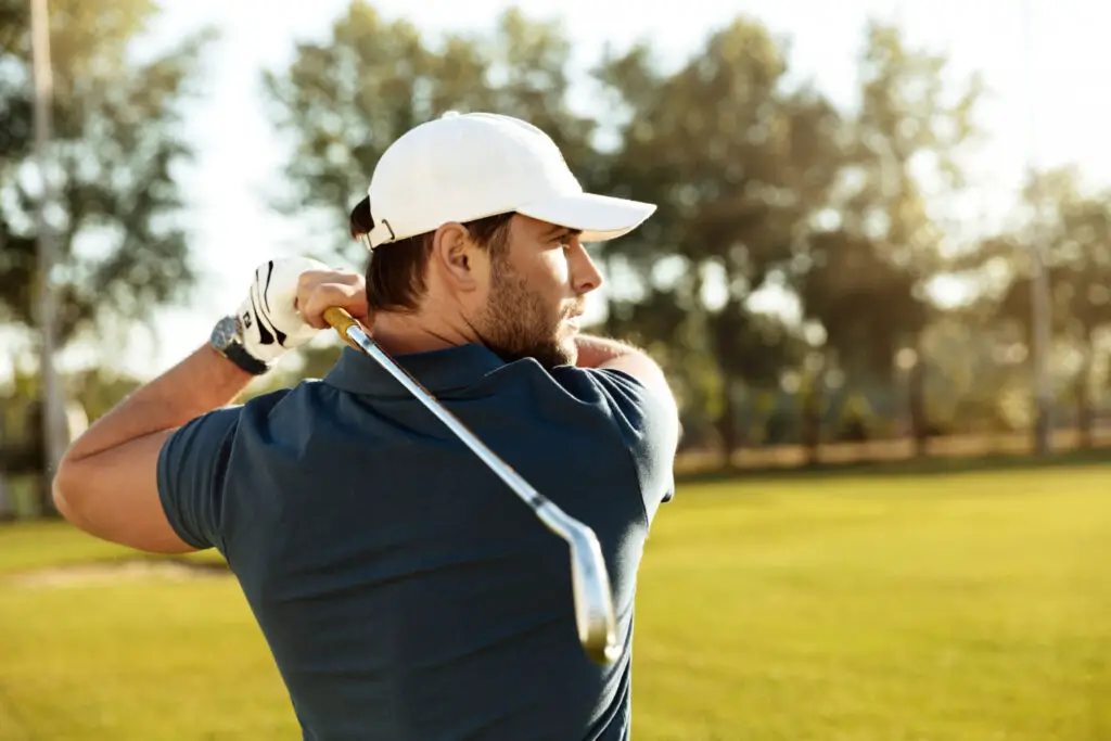 close up young concentrated man handling golf club