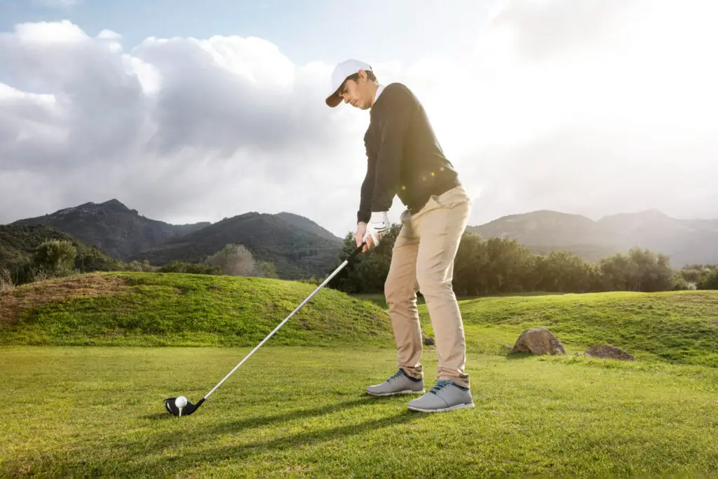 side view man playing golf field with club