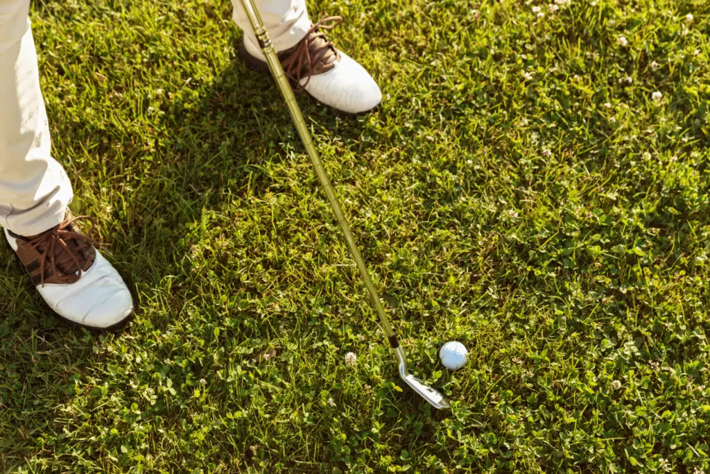 a close up male golfer teeing off