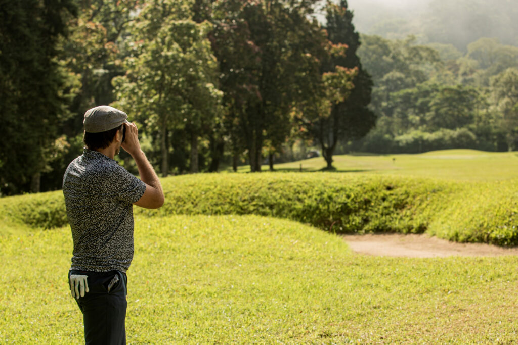 a man standing with binoculars looking in field