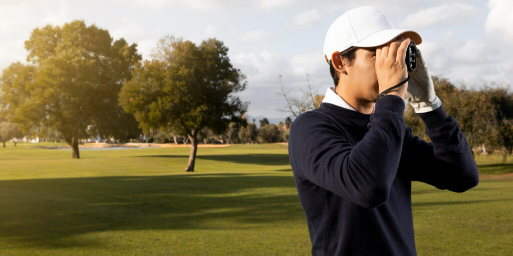 side view of a man with binoculars in golf field